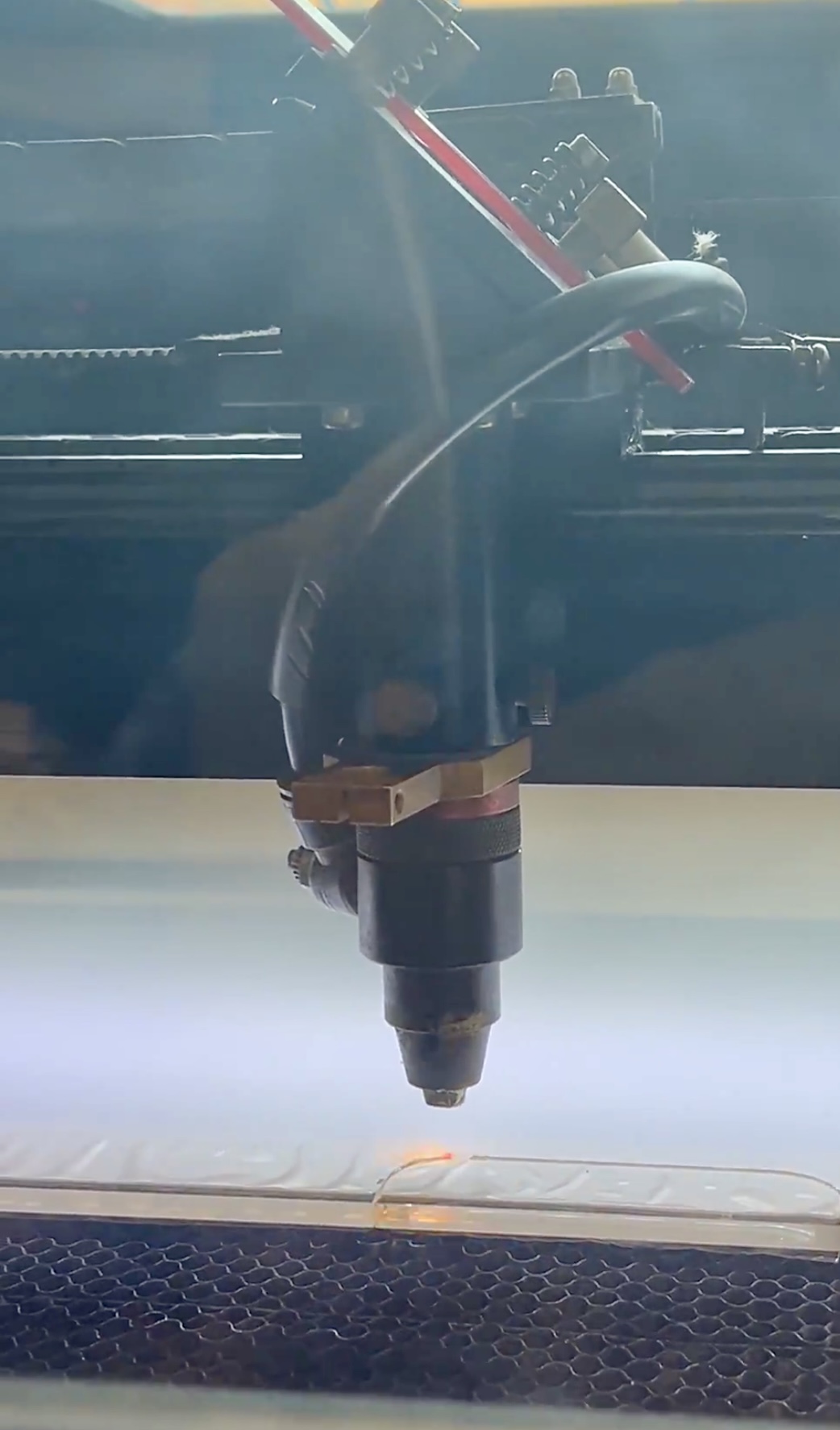 Laser head cutting a clear acrylic sheet in our Vancouver shop